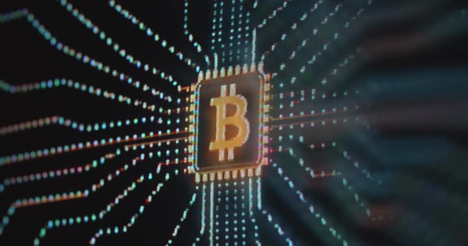 Pixelated computer screen displaying orange bitcoin symbol or logo on a computer chipset with printed circuit board running nodes and providing computing power through CPU and GPU hardware to support the BTC network