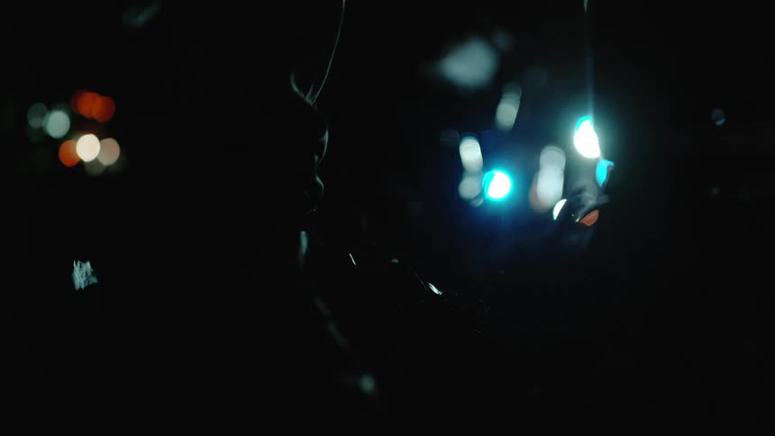 A person walks over leaves in the dark
