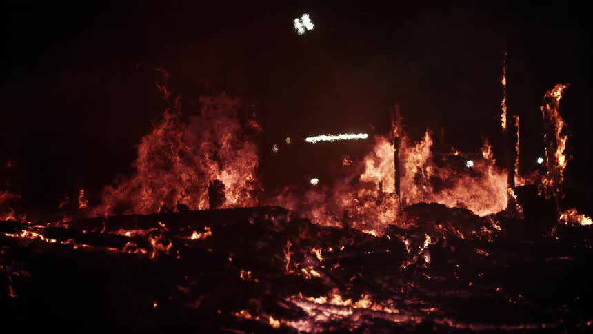 Intense fire burning a structure at night