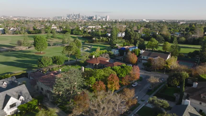 Aerial view of a Los Angeles neighborhood and golf course with a distant city skyline