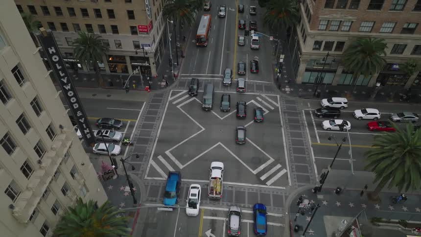 Aerial rising above cars at a traffic stop at Hollywood Blvd and Vine Street in Hollywood, California