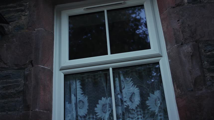 A white window is on the side of a home
