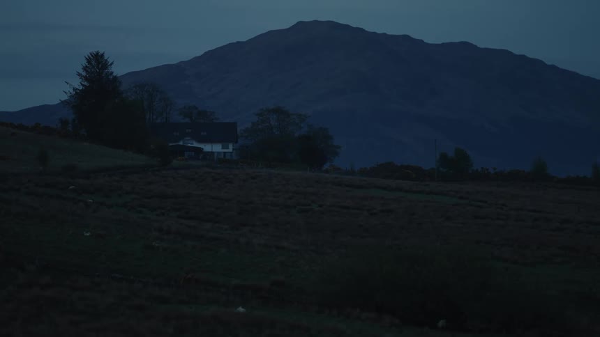 Isolated house and agricultural environment with mountains in the background