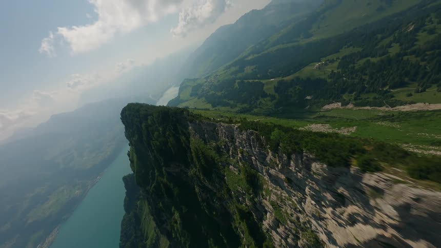 The peak of a huge mountain covered in green vegetation and there is a huge lake next to it