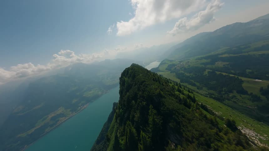 Aerial view of steep green mountains with a sea in the background