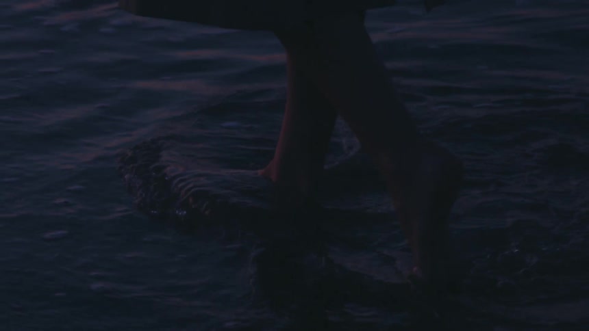 A womans feet sink in the sand as she walks