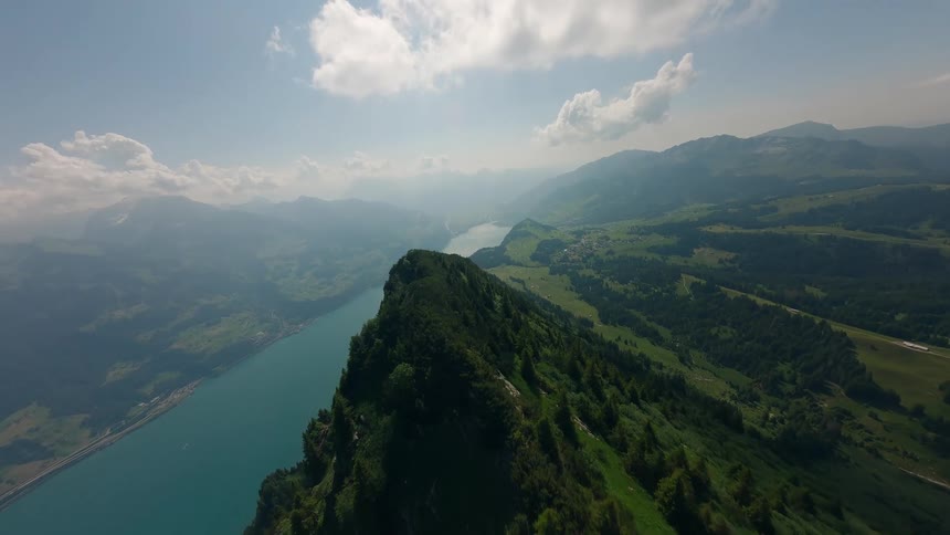 Aerial Flight Along Green Mountain Ridge with Lake View