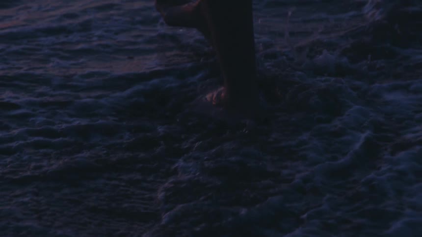 Feet of a person walking in the waters of the sea