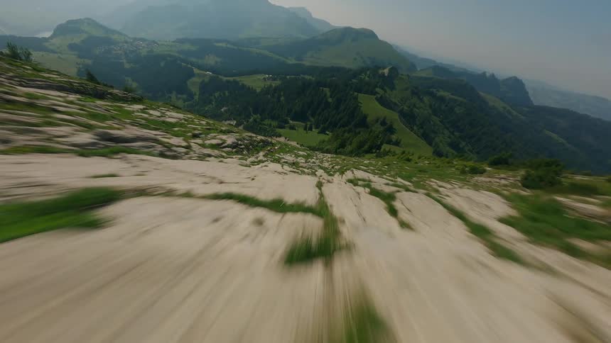 Low-Flying Drone Dives Down Swiss Mountain with Natural Slopes and Lush Conifer Forest
