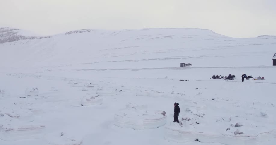 A person is walking along a snow covered field