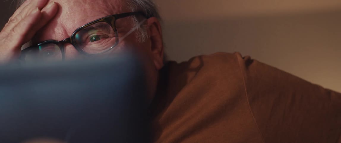Elderly man with glasses and a medical thread in his nose talking emotionally