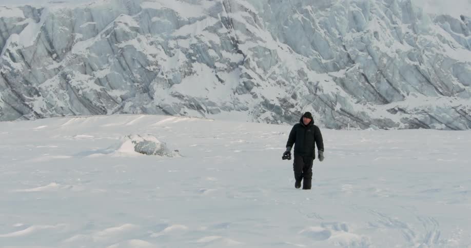 A man is hiking near an ice mountain