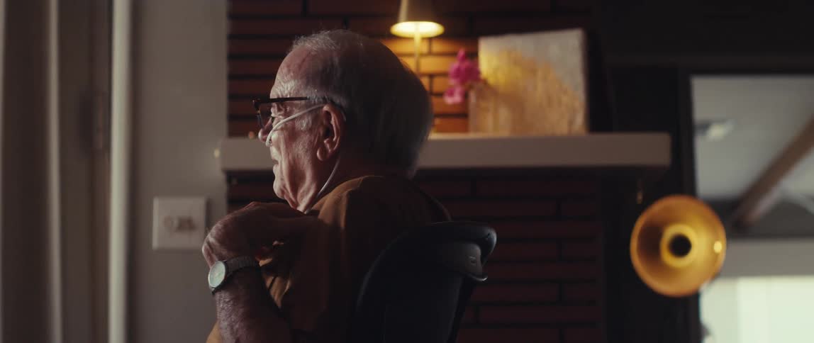 A woman on the laptop is listening to a man talk