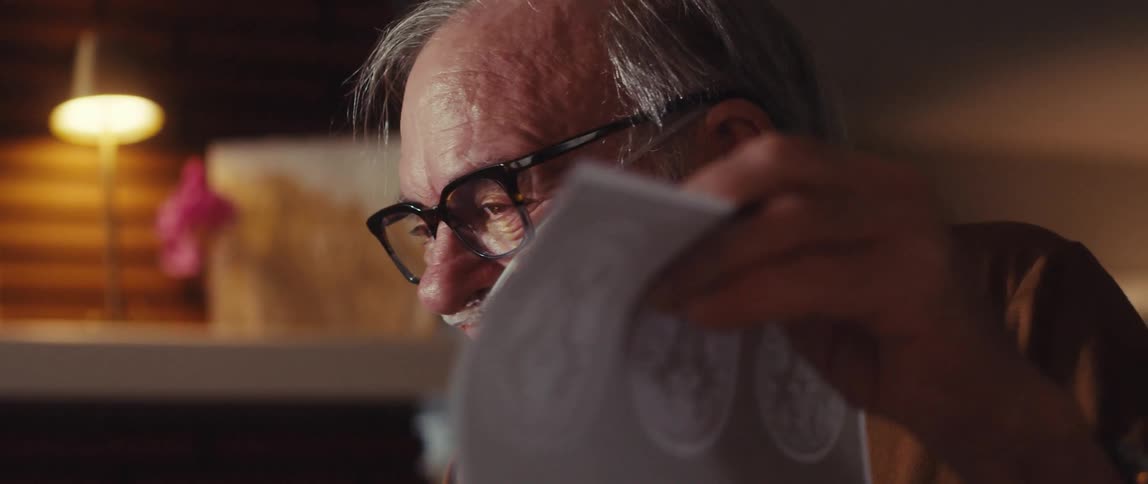 A man talks while holding up a picture of brain scans