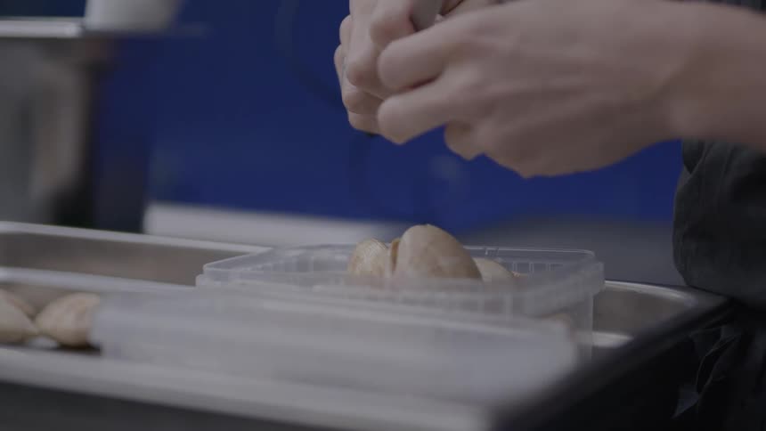 Pair of hands with a knife peeling a food
