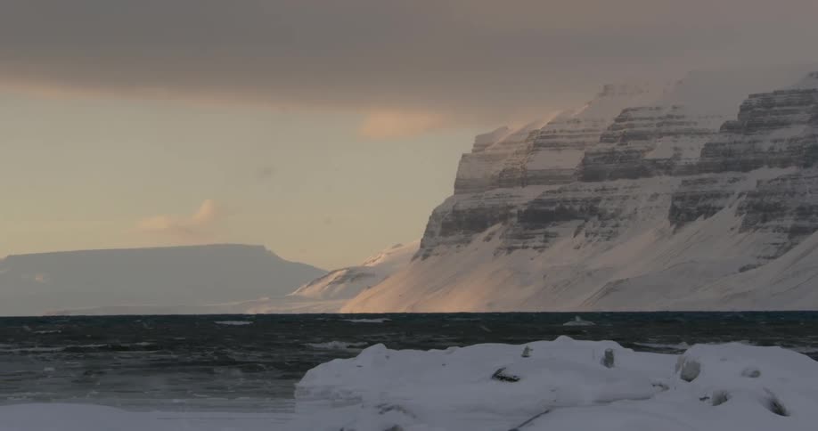 The water is lined with tall ice covered cliffs