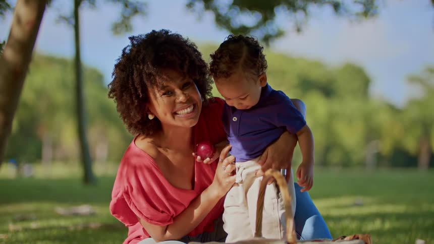 Woman on grass with her little son with happy expression