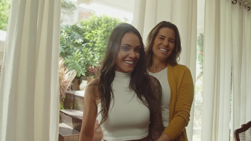 Two women are smiling and looking at each other