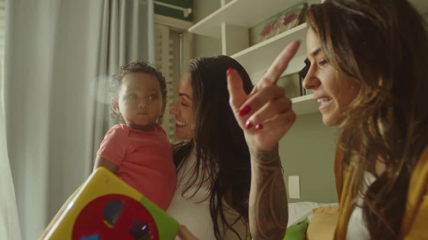 Two women playing with a little girl