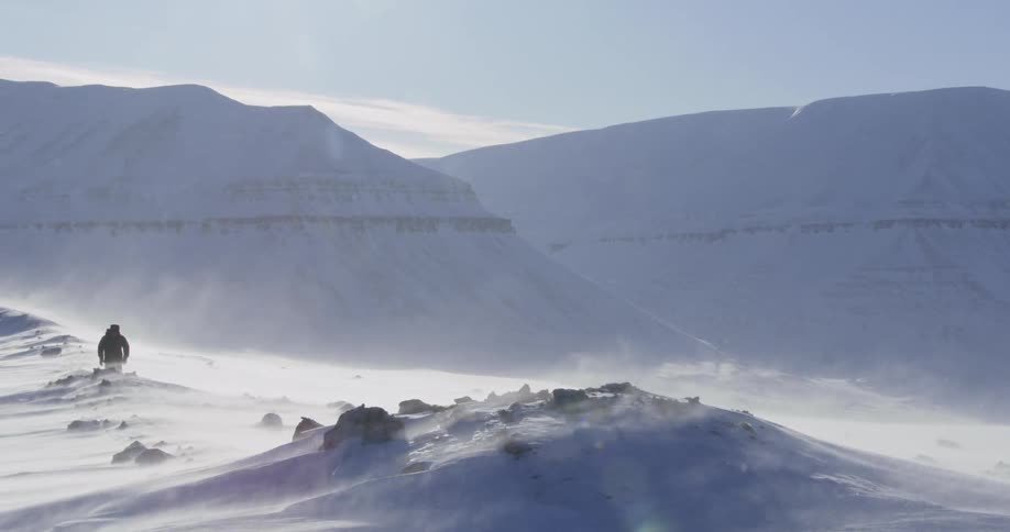 A person is hiking along the snow covered canyons