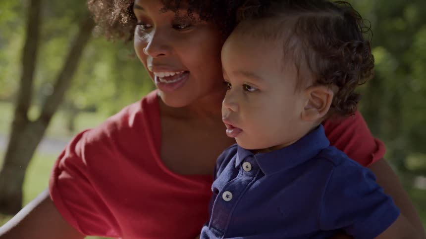 Mother sitting in an outdoor setting with her little son