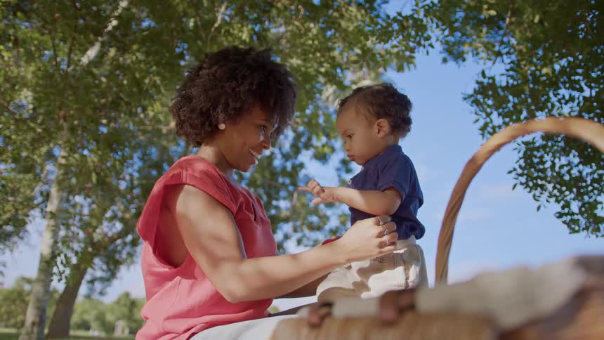 Mother and child share a bonding moment during a picnic under a tree