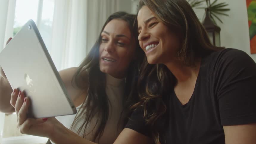 Two women smiling and enjoying a video call together on a tablet