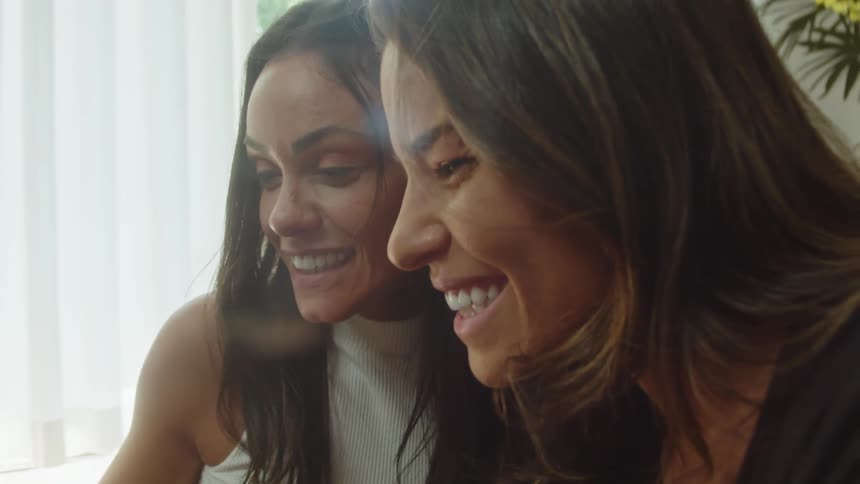 The women are side by side with big smiles on their faces