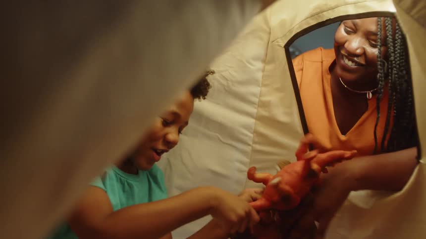 A mother plays with her son in the tent