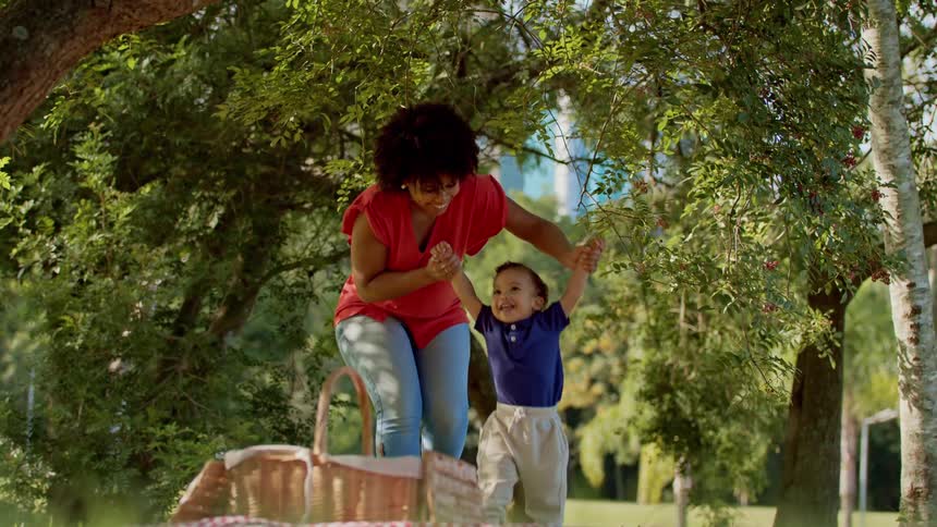 Mother playing with her son in a grassy park