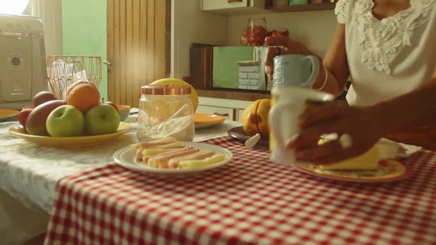 Woman taking cups from a cupboard and organizing the table