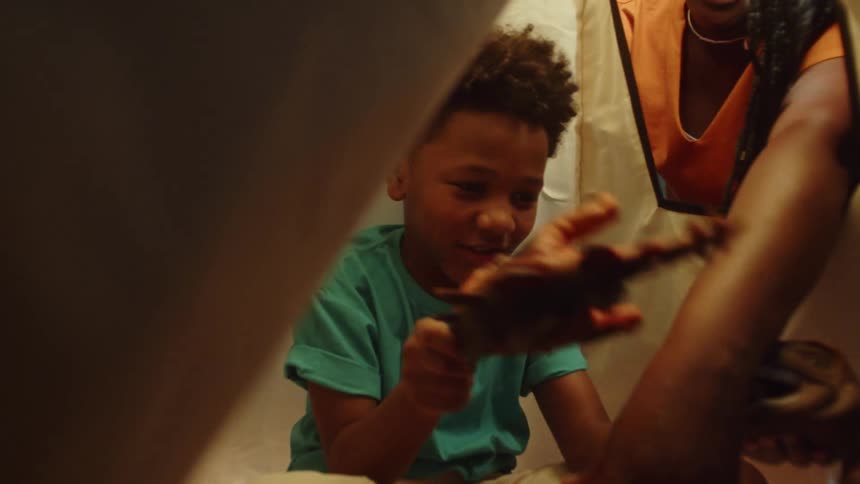 A child and his mother play with toy dinosaurs
