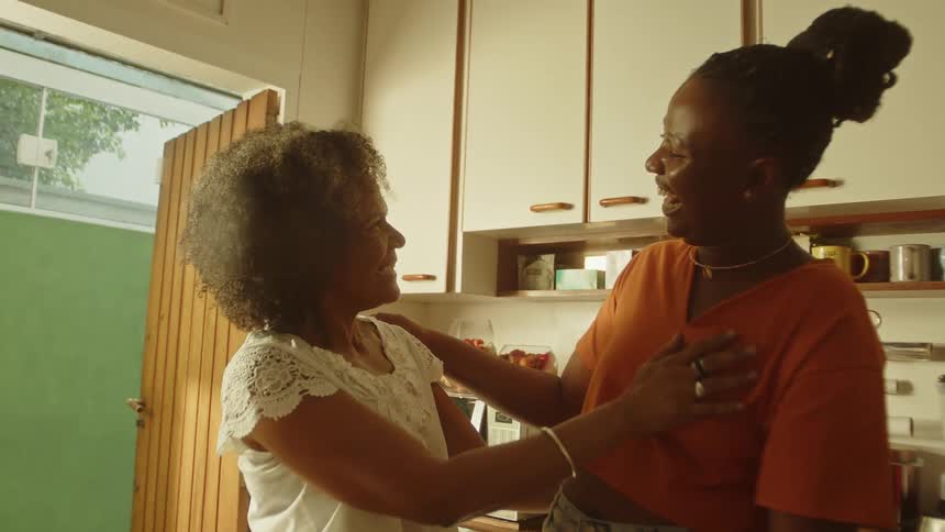 Adult mother and daughter in a loving gesture in the kitchen