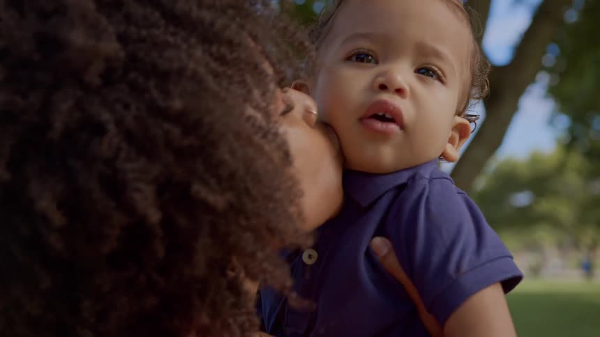 A mother kisses her son on the cheek