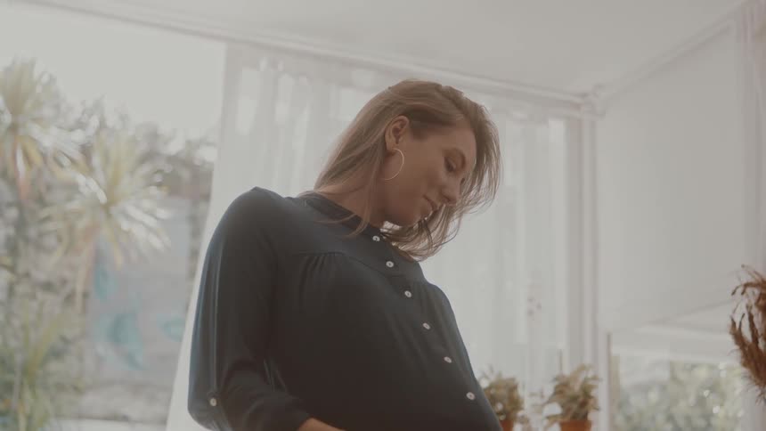 Pregnant woman running her hand over her belly