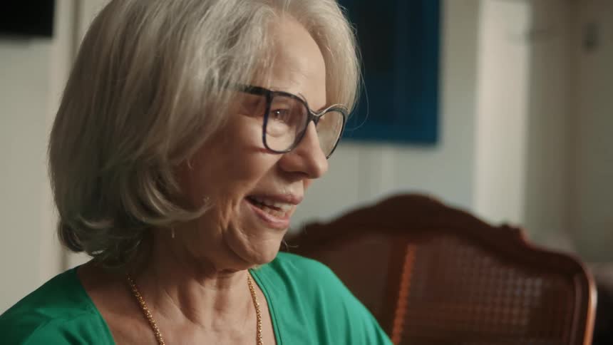 Elderly woman is sitting on a chair and talking to a friend