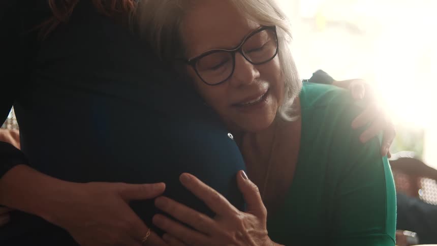 Elderly woman hugging pregnant womans belly lovingly