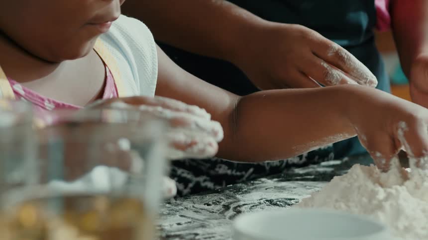 A girl is concentrating as she mixing the flour