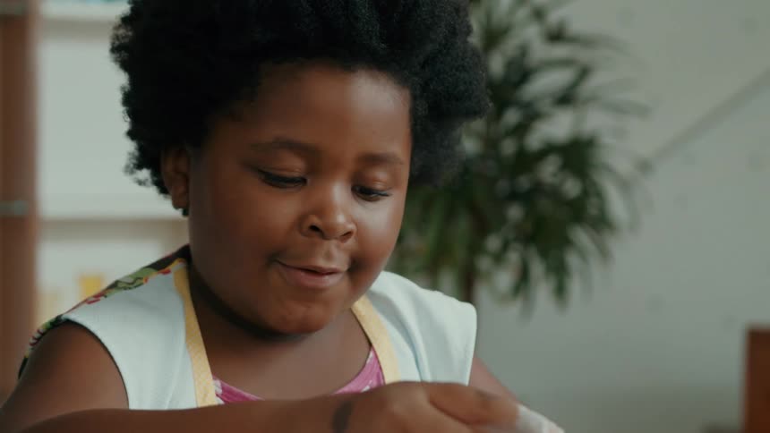 Little girl in the kitchen playing with wheat flour