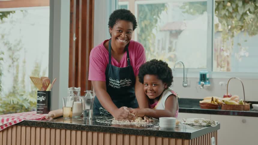 Mother and little daughter with wheat flour cooking on a countertop