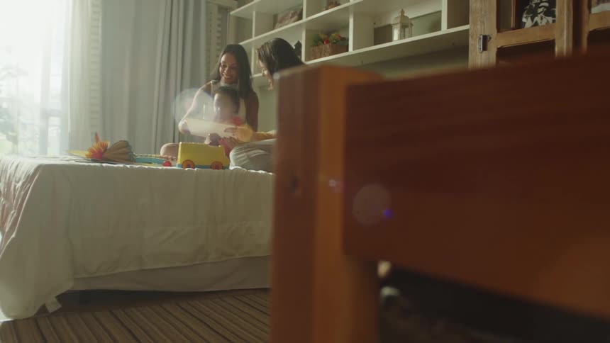 A girl is sitting with her parents playing with her toy