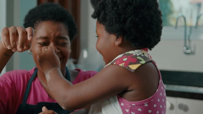 A mother and daughter tap each others noses and laugh