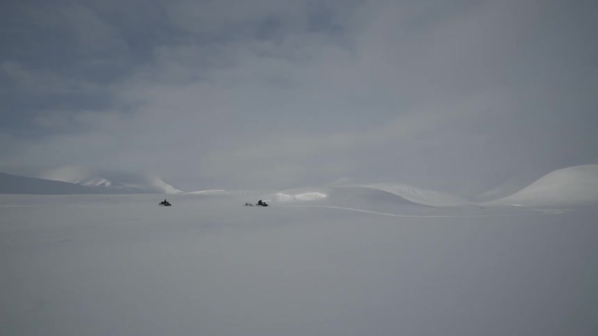 Snowmobiles are driven through a snowy landscape