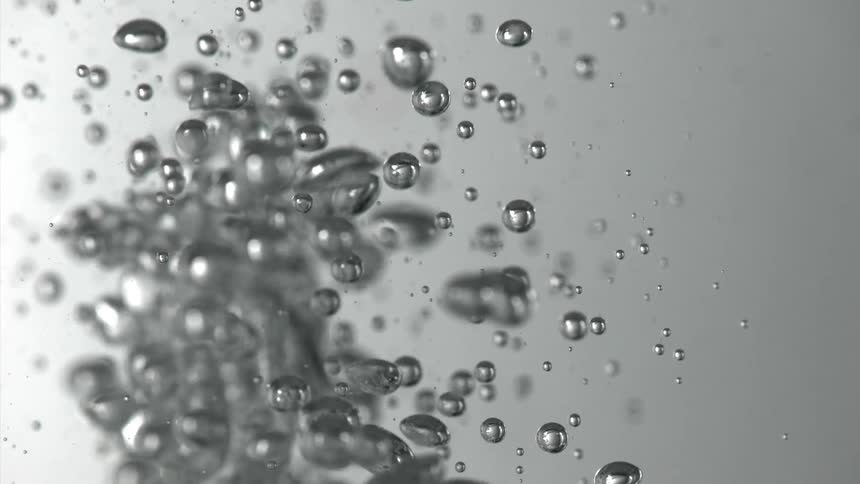 A series of bubbles form underwater at midday
