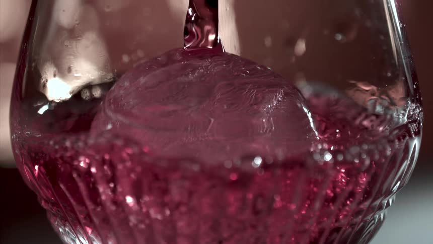 Drink filling a glass cup with an ice cube