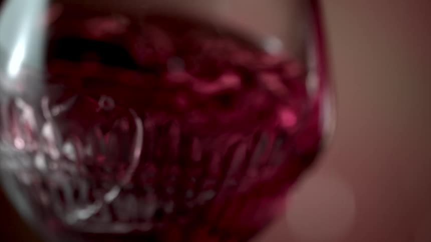 Red wine swirling in a stemless elegant wine glass