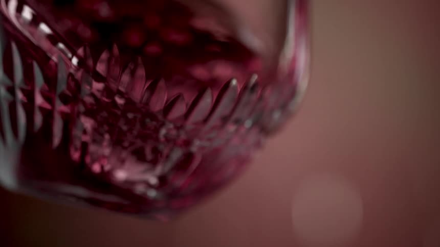 Close up of a red drink stirred in circles in a glass cup