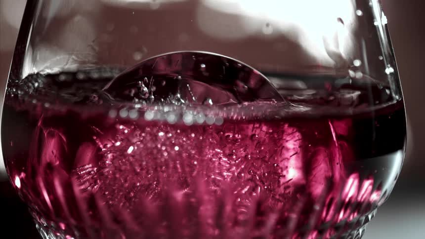 A glass of red wine with ice