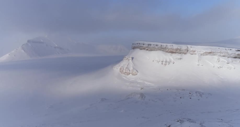 Snowy hills on a partly cloudy day