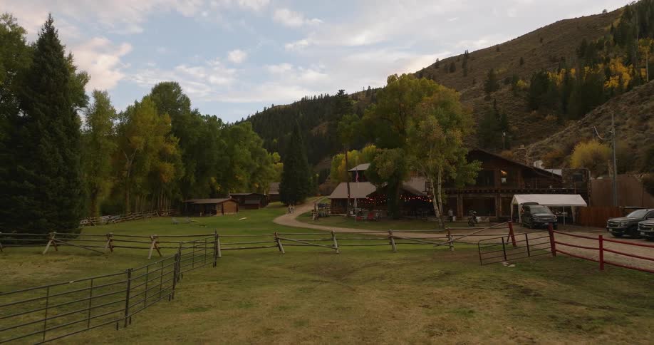 People walking around a ranch at the base of the mountain